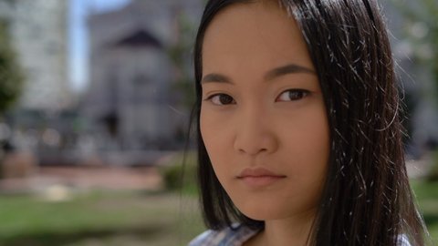 close-up, portrait. cute asian lady looks at camera. 4K