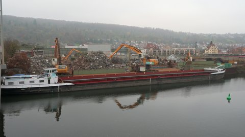 Stuttgart / Germany - 11 25 2019: Liebherr excavators loading ship with scrap metal
