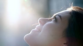Contemplative young woman looking up to sky with faith and hope. Faithful girl profile face with lens-flare outside - Powered by Shutterstock - Get 15% off with code: PIKWIZARD15