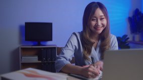 Young business Chinese woman using laptop as webcam working from home late at night for business meeting, New normal concept 