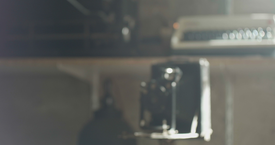 Old proffesional photocamera on tripod on sun rays.