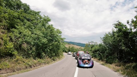 Kocani, Macedonia - 24 Jun, 2020: Classic custom VW Beetle driving on curved rural road. Volkswagon cars participating in VW Ranch Run