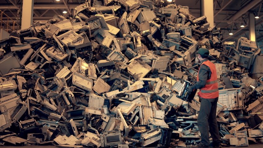 Electronic garbage recycling factory. The landfill inspector is throwing waste debris into a pile. | Shutterstock HD Video #1060240406
