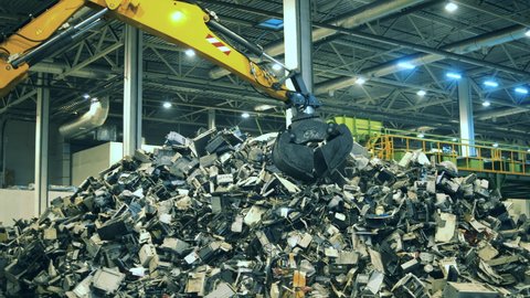 Electronic garbage recycling factory. Fragments of defective electronics being grabbed by a loader