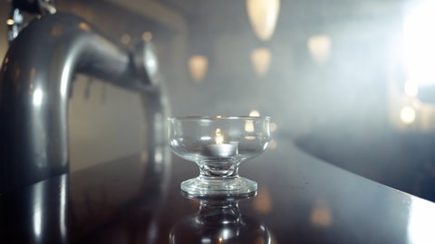 Close up of candel on bar with glass of beer gets putted down in smoky bar shot in 4k