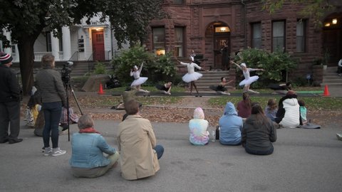 St. Paul, Minnesota. October 2, 2020A musician putting on a concert with ballet dancers performing swan lake for neighbors during the coronavirus pandemic shutdown outside of her apartment building.  