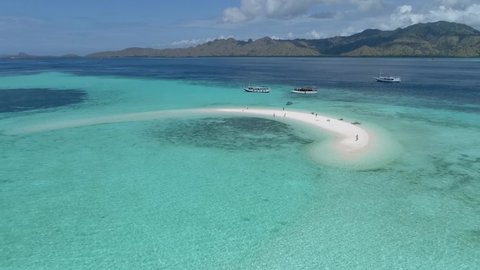 Manta ray Point. Wild islands of Indonesia. Flores. tropical paradise. Labuan Bajo. Wild beaches, blue lagoons, coral reefs. aerial drone view. boat trip safari. a group of people on a desert island