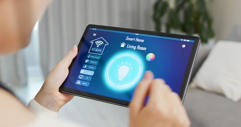 asian woman use smart home app to turn on the light with tablet pc