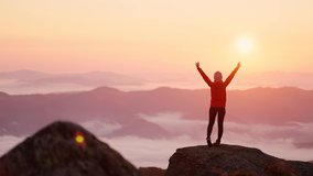 Young woman in orange jacket running up on top of mountain summit at sunset, raises arms into air, happy and drunk on life, youth and happiness. Watching the sunset with beautiful landscape - Powered by Shutterstock - Get 15% off with code: PIKWIZARD15