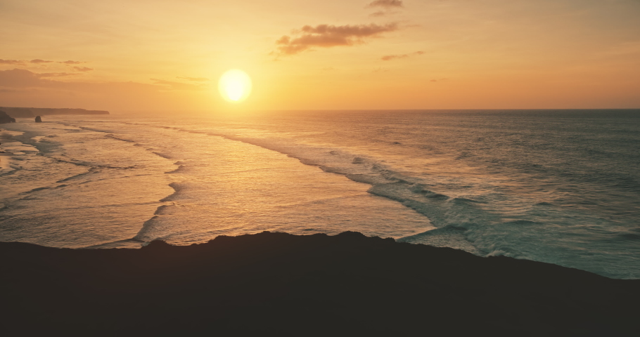 Slow motion of ocean waves at sun set light aerial view. Sunset wavy seascape at tropical paradise resort of Sumba Island, Indonesia, Asia. Cinematic nobody nature scenery at soft sunlight drone shot Royalty-Free Stock Footage #1060259693