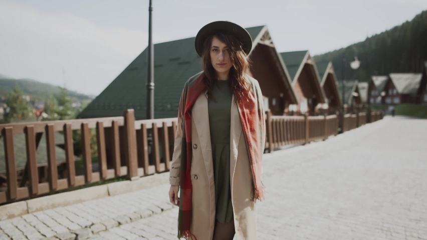 hipster girl in a green hat and cloak walks the streets of Switzerland.Woman In Hat Enjoying Sun