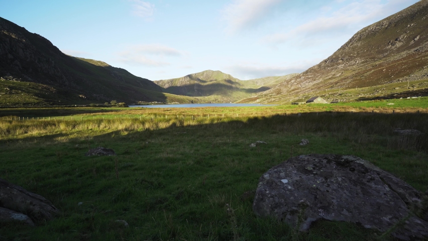 Ogwen valley lake and mountains with deep shadows and grassy fields