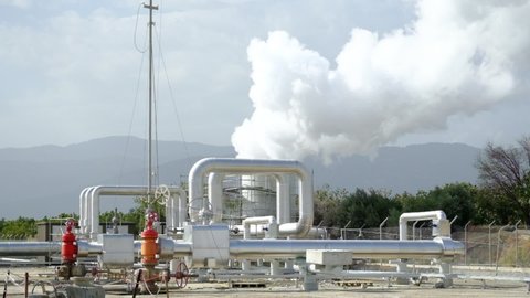 Geothermal station with steam and pipes in the rainforest. Billowing steam from smoke stack filling sky, super slow motion close up. Buharkent, Turkey