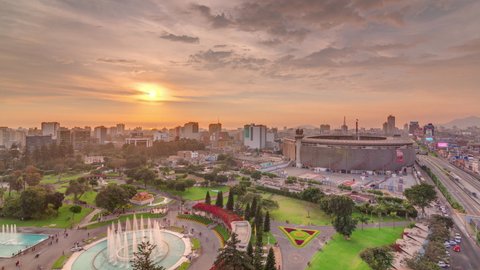 Aerial sunset view of the National stadium in the Peruvian capital Lima with Via Expresa highway timelapse. Landscape of Park of the Reserve and city skyline on a background in South America. Peru