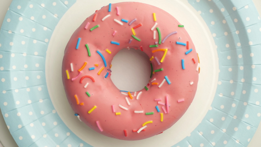 Bright and colorful sprinkled donut close-up shot spinning on a color disposable paper plate.
Top view. Seamless looping. | Shutterstock HD Video #1060271159