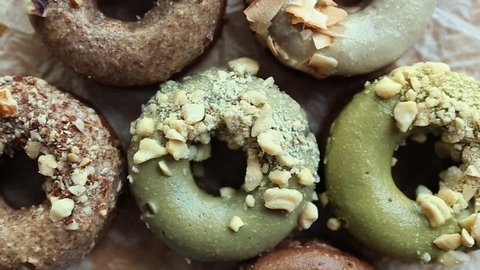 Delicious donut set filmed directly from above on wooden plate.Fresh donuts prepared for breakfast.Dessert food for lunch,coffee break in Italian cafe.Tasty natural doughnuts cooked in bakery