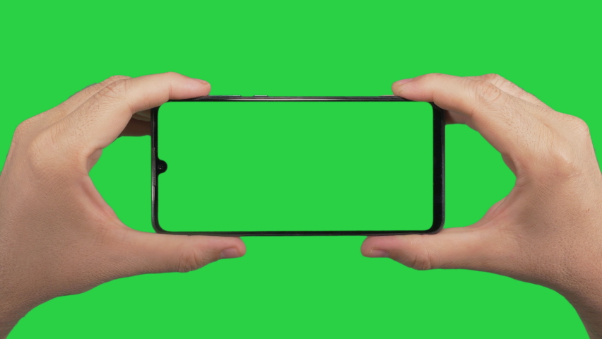 Hands holding cell phone with green screen in green background | Shutterstock HD Video #1060271615