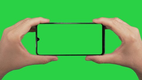 Hands holding cell phone with green screen in green background