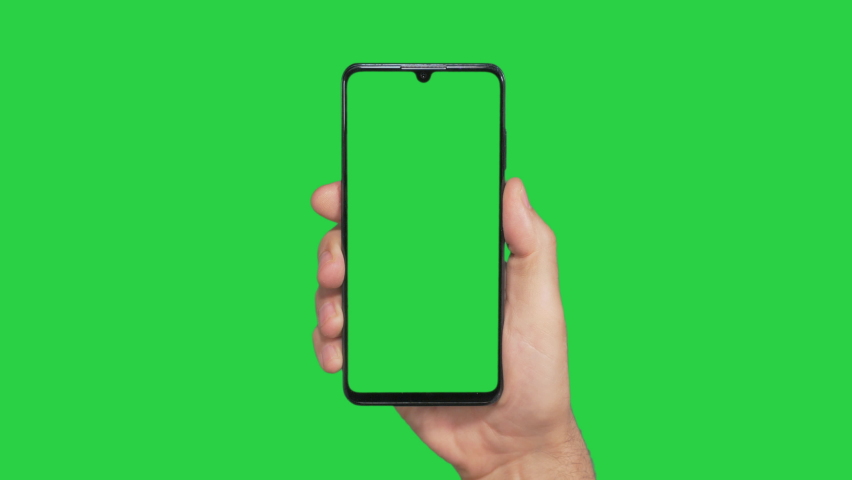 Hands holding cell phone with green screen in green background Royalty-Free Stock Footage #1060271621