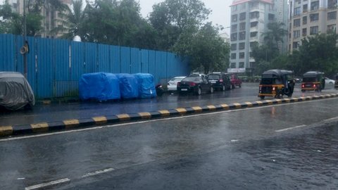 Vehicles Driving On The Wet Street In Mumbai, India During Rainy Season - slow panning shot