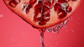 Super Slow Motion of Water Splash on Fresh Backlit Pomegranate Slice. Shot at 1000 fps. - Powered by Shutterstock - Get 15% off with code: PIKWIZARD15