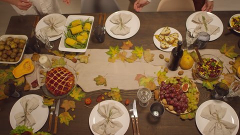 Top view shot footage of unrecognizable man finishing Thanksgiving dinner setting with putting tasty roasted turkey on table