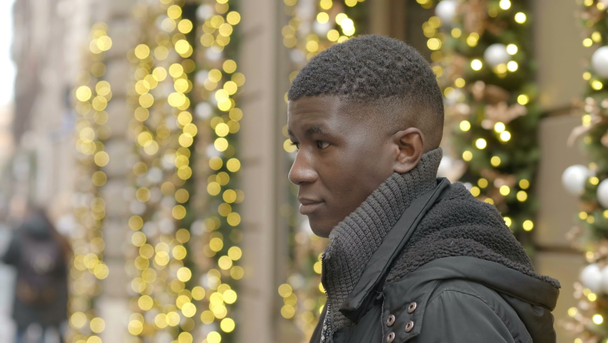 Happy black african youg man smiling at camera at Christmas- outdoor