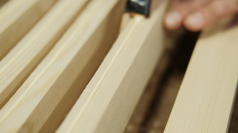 Putting wood glue onto a wooden board. Bonding wood in the workshop. Joiner, woodworker, carpenter applies glue to workpieces. Carpentry, craftsmanship, Handicrafts.