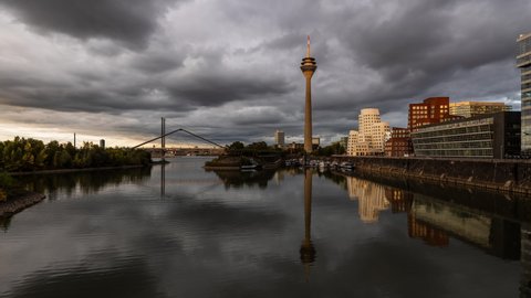 Düsseldorf, Germany - September 27 2020: Day to Night time lapse from the skyline of Düsseldorf with the River Rhine and the Rheinturm TV Tower