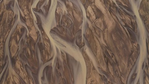 Aerial: Glacial river Meltwater mixed with natural mineral sediment in river deltas creating stunning pattern Iceland View Forwards