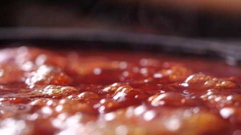 Close-up of boiling red tomato sauce in slow motion for making pizza or pasta