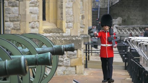 London, UK - April, 2019: British guard in traditional red-black uniform on military duty in the army of the Queen of England. Sentry on duty at the Tower of London. Super slow motion, video footage.