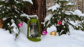 Christmas time concept. Snow falling down in the forest with new year balls.