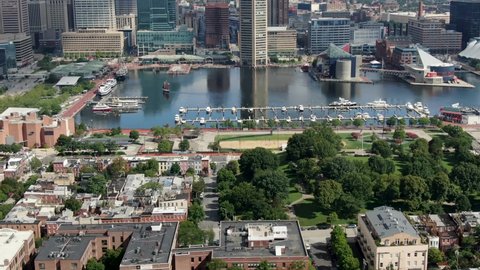Baltimore , MD / United States - 08 23 2020: Aerial tilt up reveals Federal Hill, Inner Harbor, boats and clipper ship in marina, Patapso River, Chesapeake Bay, summer sunny day