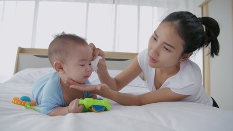 Family concept. Mother is wiping the snot on the baby. 4k Resolution.