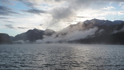 Maloja mountain Pass, Switzerland. Landscape of the lake Sils in the morning during the fall time. The fog covers the lake and the shores. Traditional Swiss contest.  