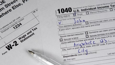 W-2 and 1040 Tax Form. Tax Payment Concept. Filing Taxes Document on Table in Office. Individual Income Tax Return