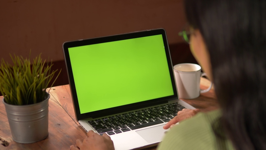 Side View of . Over the shoulder shot of a business woman working in office interior on pc on desk, looking at green screen. Office person using laptop computer with laptop green screen. Royalty-Free Stock Footage #1060309868