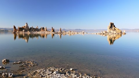 The calcareous tufa formation reflects on the smooth waters of Mono Lake, one of the oldest lakes in North America. The Mono Lake Tufa State Natural Reserve, California, United States. Sunset shot.