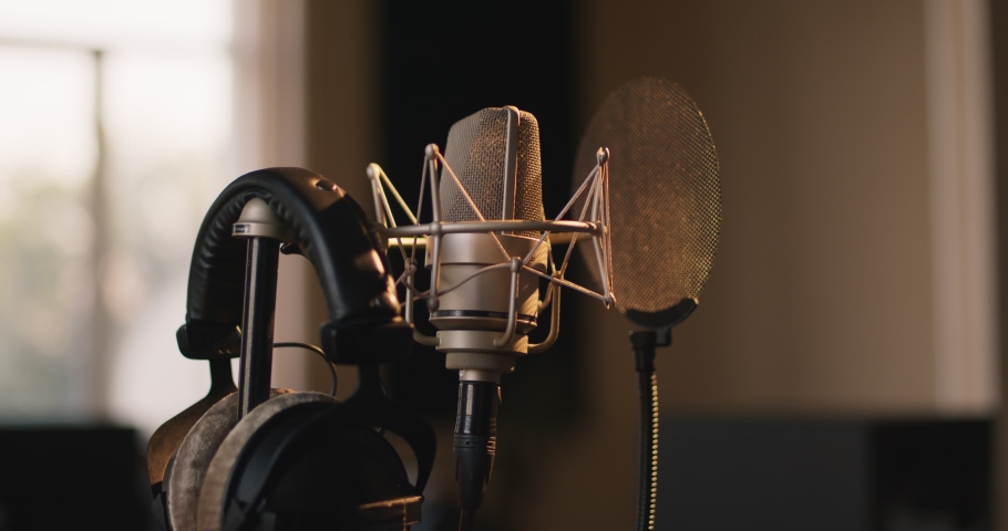 Recording concept. Tracking shot of professional microphone and headphones at sound record studio, close up Royalty-Free Stock Footage #1060310336