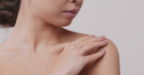 Perfect young skin. Asian woman touching her neckline, close up beauty portrait