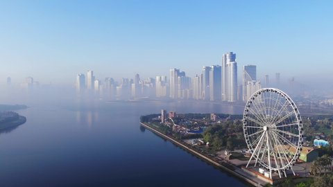 View from above of Sharjah's Khalid Lake, Eye of Emirates, Sharjah Skyline on a foggy morning, United Arab Emirates, 4K video