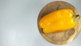 4K view of yellow bell peppers rotating on a wooden plate on white - Powered by Shutterstock - Get 15% off with code: PIKWIZARD15