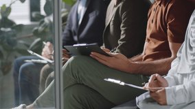 Tilt up shot of young handsome middle eastern man sitting with multiethnic candidates, filling application form and then posing for camera with smiling while waiting for job interview - Powered by Shutterstock - Get 15% off with code: PIKWIZARD15