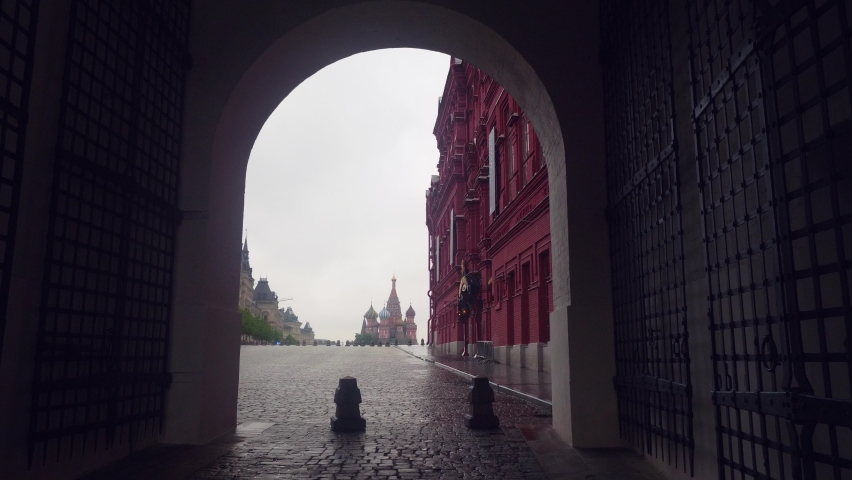 View of red square through archway in cloudy rainy day. Emptiness of touristic place during pandemic.
