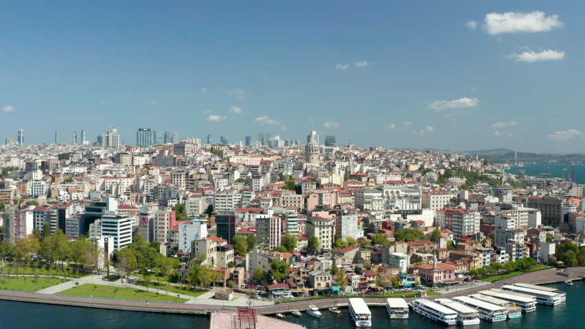 Beyoglu, Istanbul Establishing Shot with beautiful clear blue Sky and Galata Tower on Bosphorus Waterside, Slow Aerial slide right
