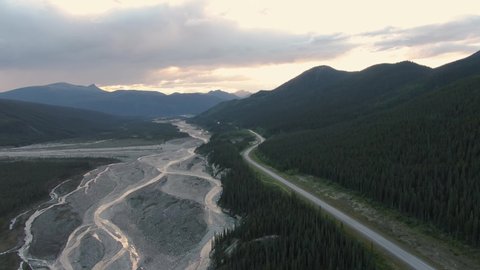 Beautiful View of Scenic Road by Glacial River at Sunset. Aerial Drone Shot. Northern Rocky Mountains, British Columbia, Canada.