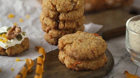 Keto Carrot oatmeal cookies. Healthy homemade ketogenic diet dessert decorated with white cream, nut and seeds. set on white cafe table background.
