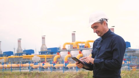 mining lifestyle oil gas production industry concept . engineer man power and energy using digital tablet. worker a in helmet works at an oil gas plant. engineer a studies documents business industry
