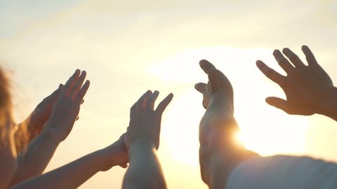 People hands reach out to sun and god at sunset. Happy family together hands up religion. Teamwork. Prayer for help. People turn to God together in prayer. People in religion. Helping hands sun. 